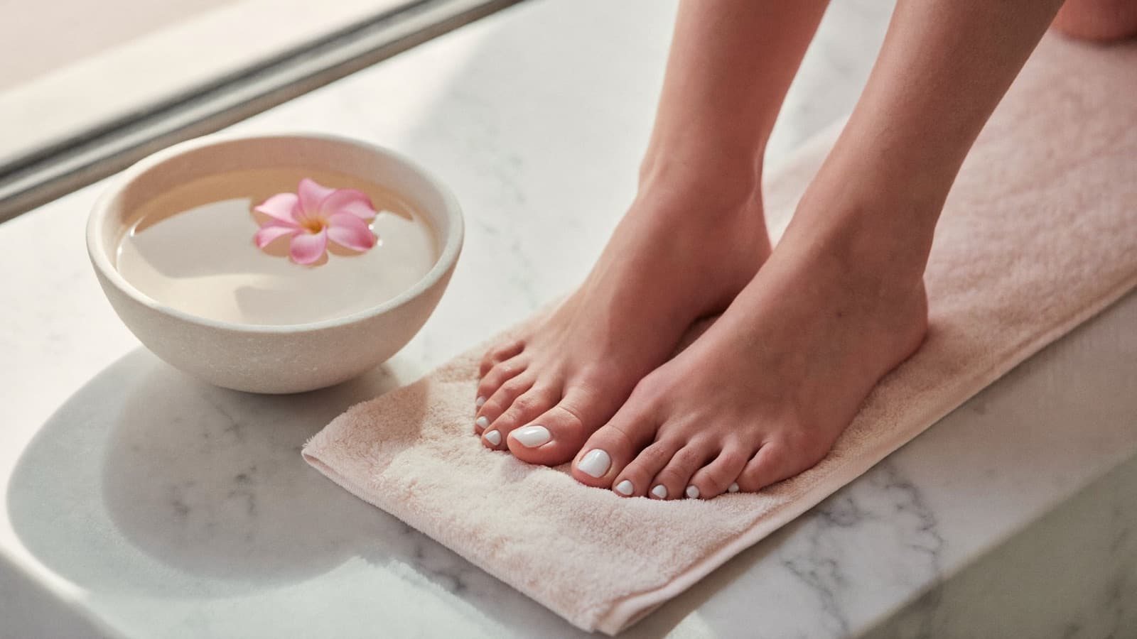 Piedi curati con smalto nude dopo un pedicure estetico